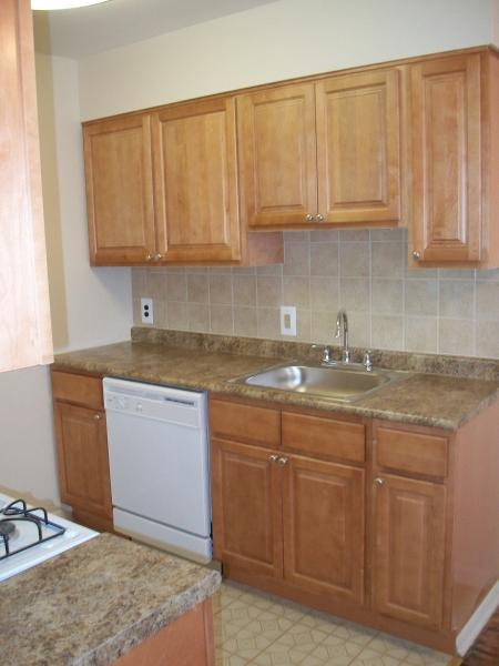 Kitchen with brown cabinetry at 洛伍德庄园 apartments for rent